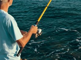 Histórias de quem ainda não ganhou 1 milhão. Homem em alto mar com a vara de pesca na mão.