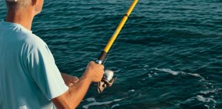 Histórias de quem ainda não ganhou 1 milhão. Homem em alto mar com a vara de pesca na mão.