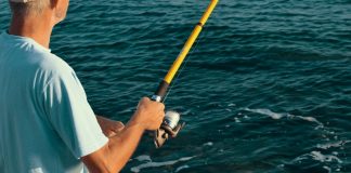 Histórias de quem ainda não ganhou 1 milhão. Homem em alto mar com a vara de pesca na mão.