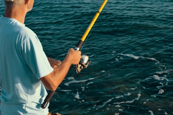 Histórias de quem ainda não ganhou 1 milhão. Homem em alto mar com a vara de pesca na mão.